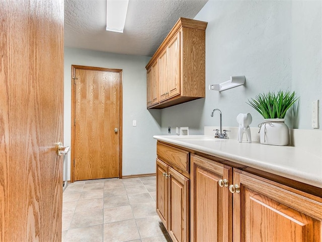 2508 Hamden Ave, Norman, OK 73069 - laundry area featuring cabinet space, washer hookup, a sink, light tile patterned floors, and hookup for an electric dryer