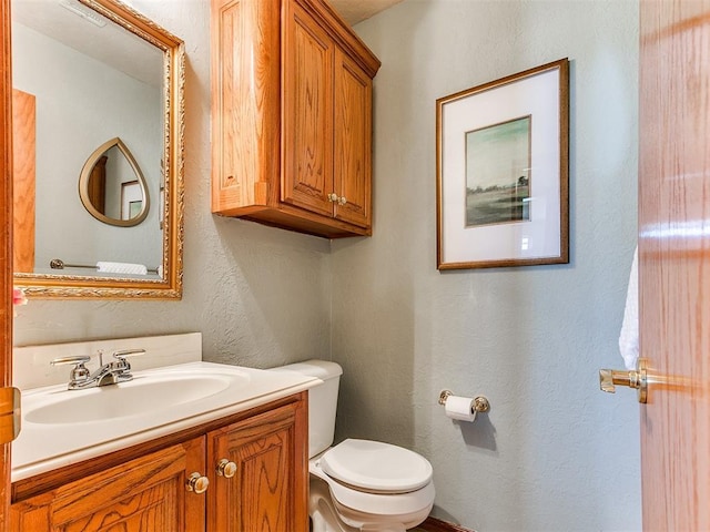 2508 Hamden Ave, Norman, OK 73069 - bathroom with vanity, a textured wall, and toilet