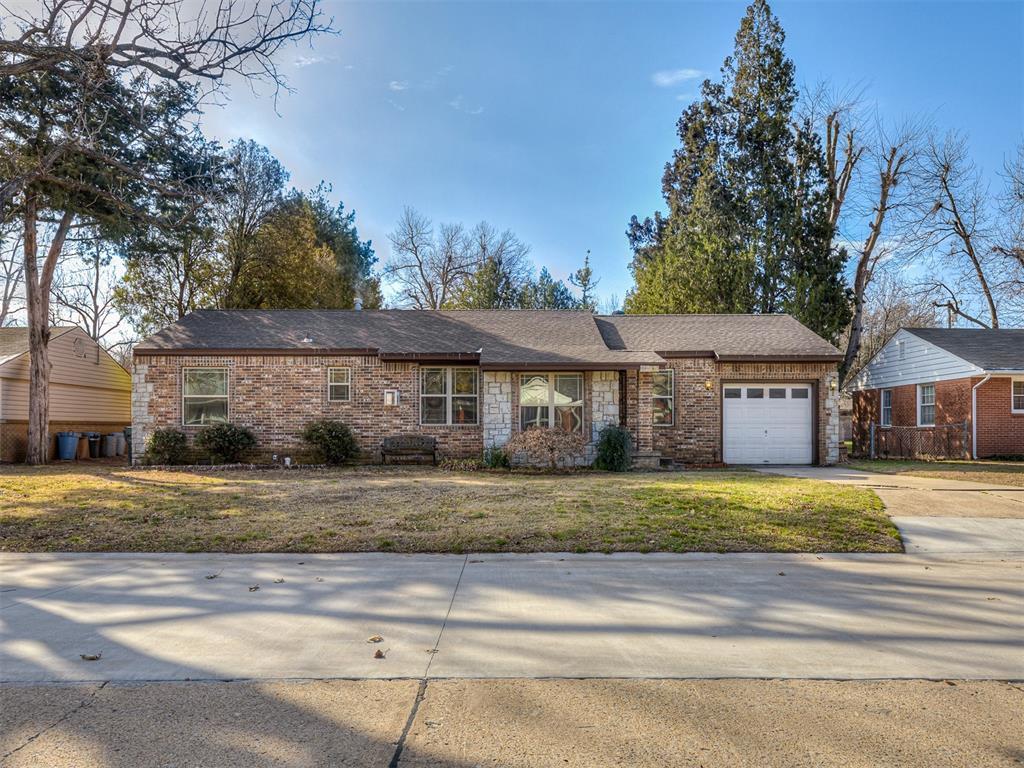 ranch-style house with a garage and a front lawn