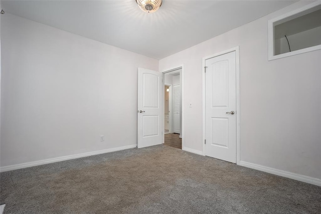 unfurnished bedroom with dark carpet