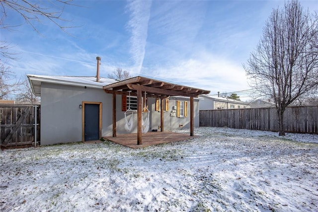 snow covered rear of property with a pergola