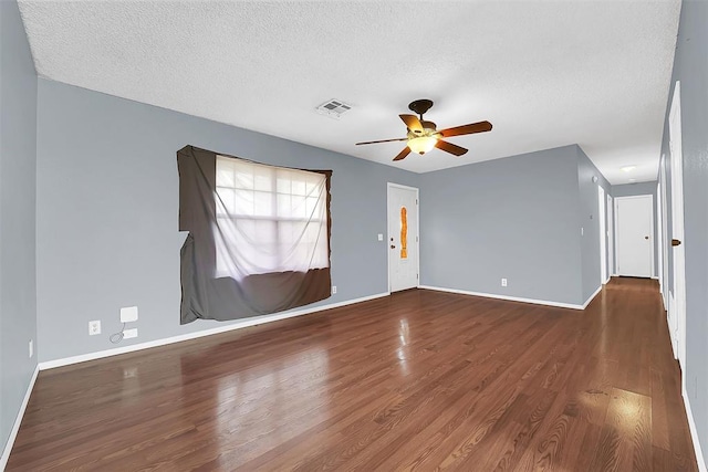 spare room featuring wood-type flooring, ceiling fan, and a textured ceiling