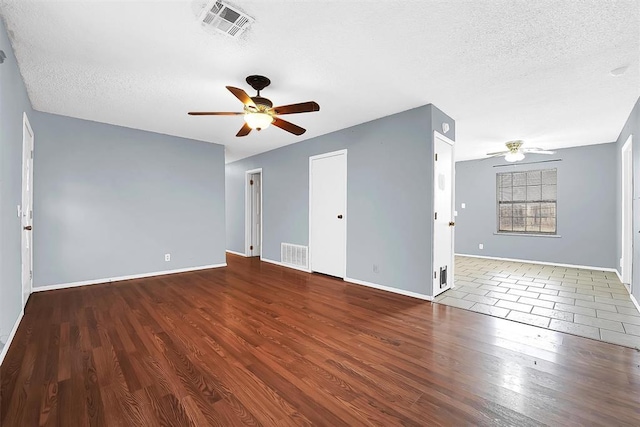 unfurnished room featuring ceiling fan, dark hardwood / wood-style flooring, and a textured ceiling