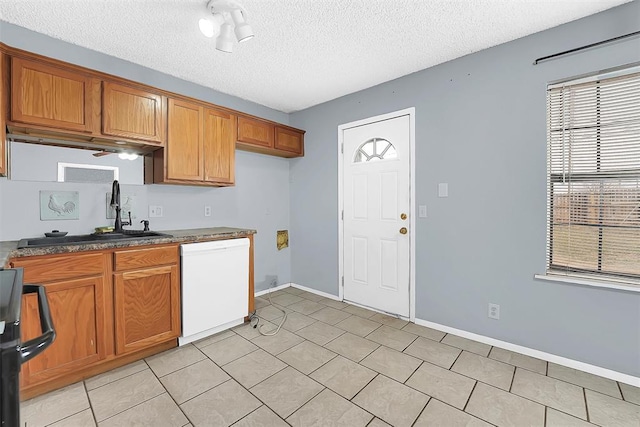 kitchen featuring light tile patterned flooring, sink, range, white dishwasher, and a textured ceiling