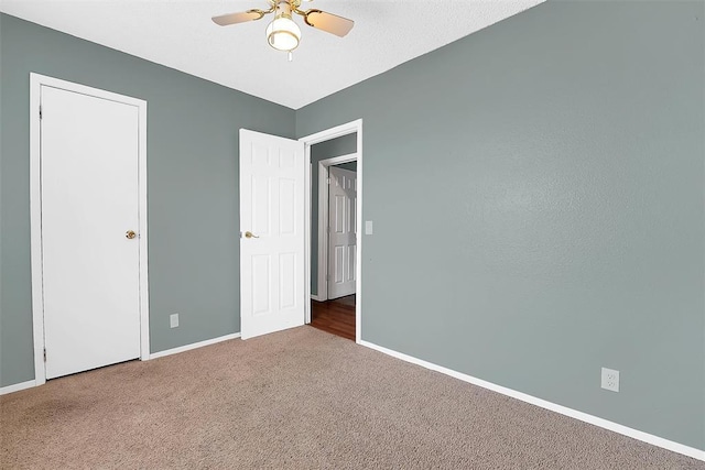 unfurnished bedroom featuring carpet floors and ceiling fan