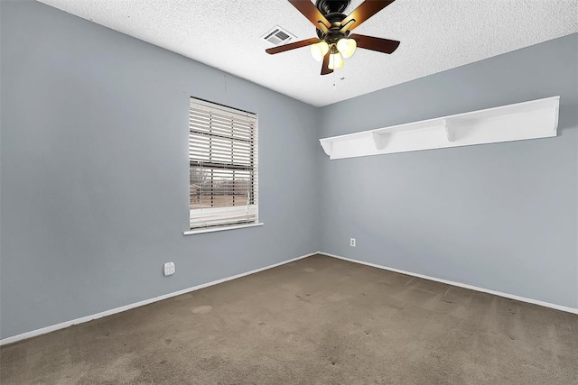 empty room featuring ceiling fan, a textured ceiling, and dark carpet