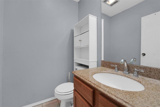 bathroom featuring vanity, tile patterned flooring, and toilet