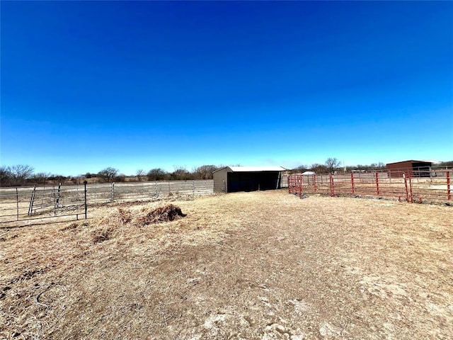 view of yard featuring an outbuilding, an exterior structure, and a rural view