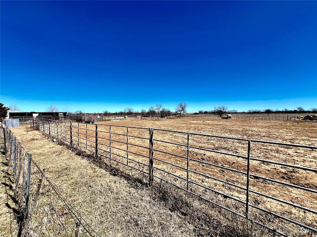 view of yard featuring a rural view and fence