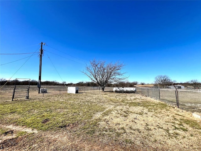 view of yard with fence and a rural view