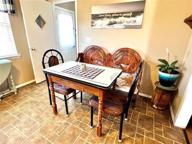 dining room with stone finish floor and baseboards