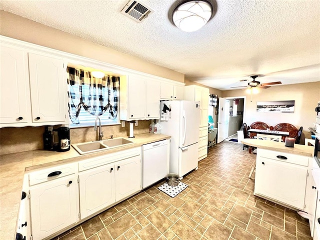 kitchen featuring white appliances, a sink, visible vents, white cabinets, and light countertops