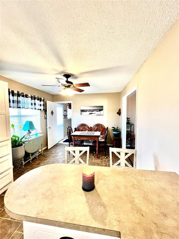 dining space with ceiling fan and a textured ceiling