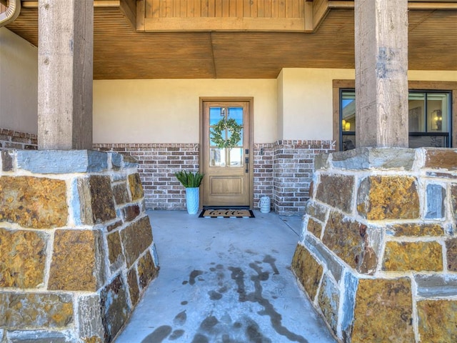 property entrance featuring stucco siding and brick siding