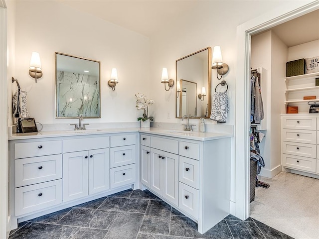 bathroom featuring double vanity, a marble finish shower, and a sink