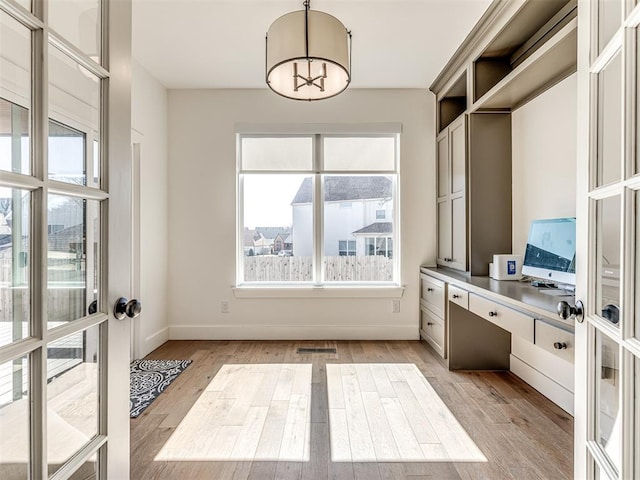 interior space featuring a chandelier, visible vents, baseboards, french doors, and light wood finished floors