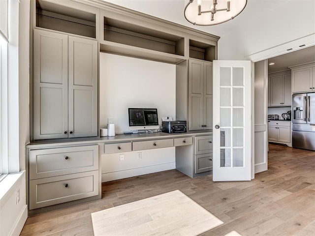 interior space featuring light wood finished floors and an inviting chandelier