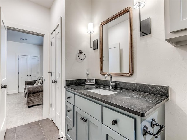 bathroom with tile patterned flooring, visible vents, a closet, and vanity