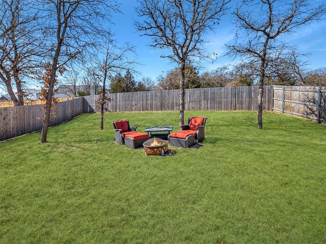 view of yard featuring a fenced backyard and a fire pit