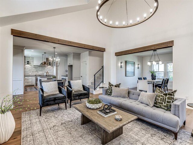 7308 Sunset Sail Ave, Edmond, OK 73034 - living area featuring an inviting chandelier, stairway, wood finished floors, and a towering ceiling