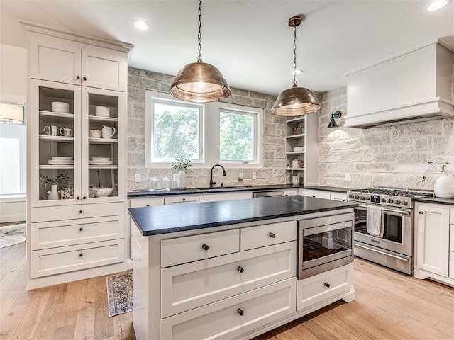 7308 Sunset Sail Ave, Edmond, OK 73034 - kitchen featuring a sink, light wood-style flooring, appliances with stainless steel finishes, and backsplash