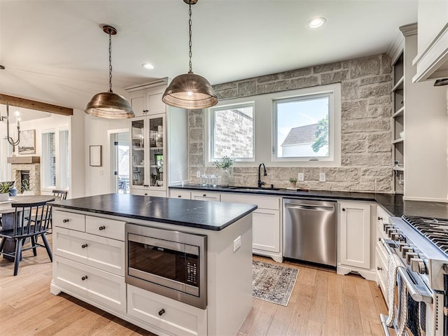 7308 Sunset Sail Ave, Edmond, OK 73034 - kitchen featuring light wood-style floors, appliances with stainless steel finishes, and dark countertops