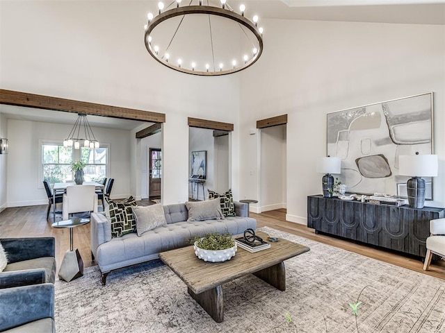 7308 Sunset Sail Ave, Edmond, OK 73034 - living area with baseboards, a high ceiling, wood finished floors, and a notable chandelier