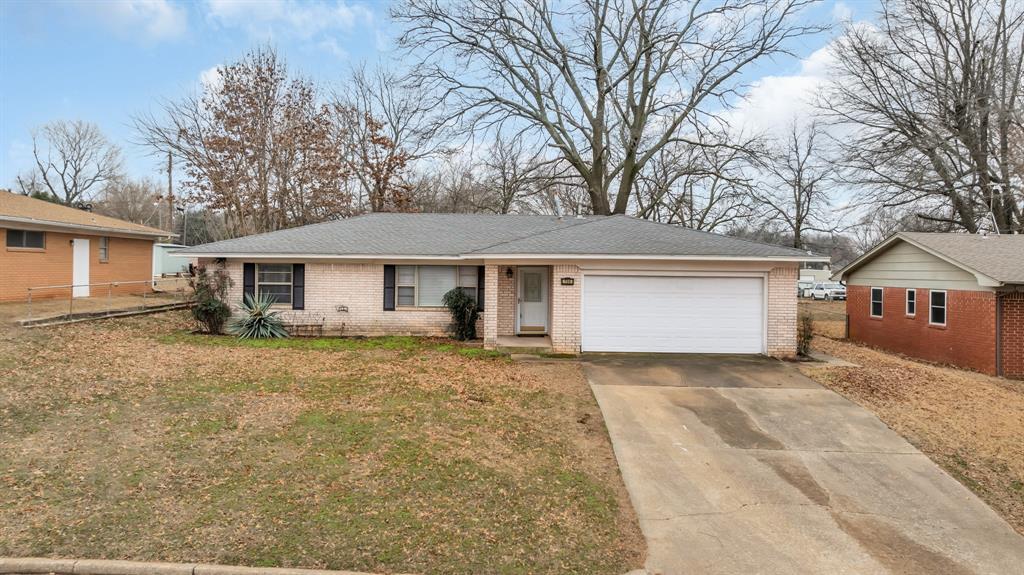 ranch-style house with a garage and a front lawn