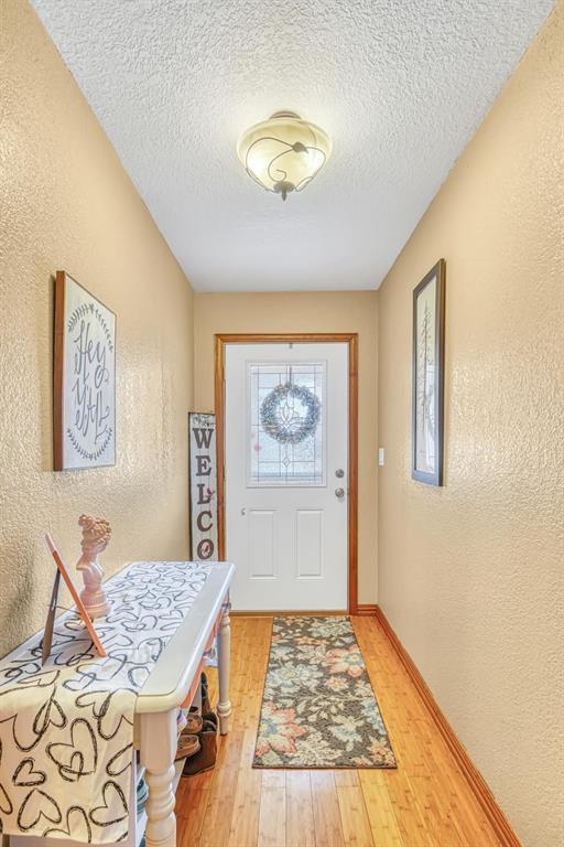 doorway featuring hardwood / wood-style flooring and a textured ceiling