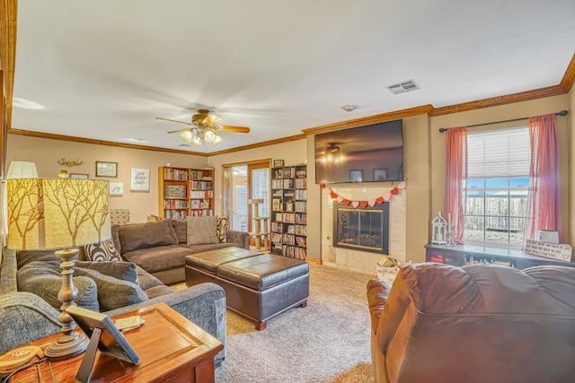 living room with light carpet, a tiled fireplace, ornamental molding, and ceiling fan