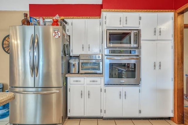 kitchen with white cabinetry, appliances with stainless steel finishes, and light tile patterned floors