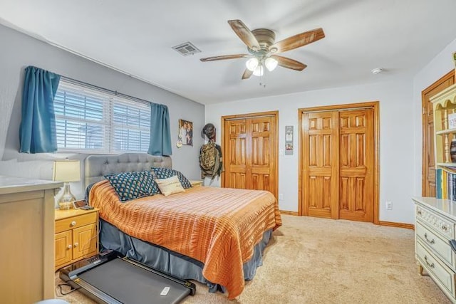 carpeted bedroom featuring two closets and ceiling fan