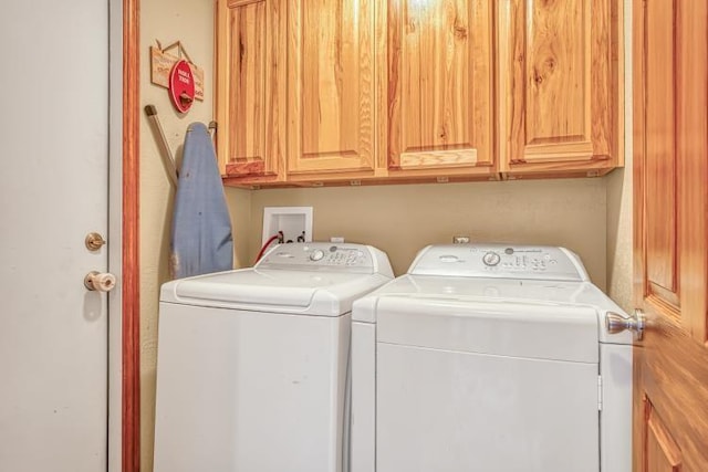 clothes washing area featuring cabinets and washing machine and clothes dryer