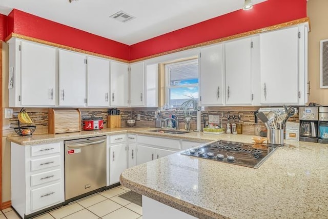 kitchen with tasteful backsplash, stainless steel dishwasher, black cooktop, and white cabinets