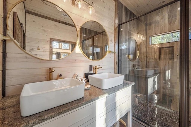 bathroom featuring a sink, wood walls, and double vanity