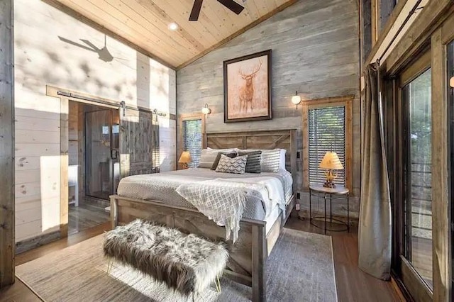 bedroom featuring high vaulted ceiling, a barn door, wooden walls, wood finished floors, and wood ceiling