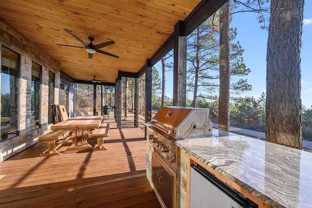 unfurnished sunroom featuring wood ceiling and ceiling fan