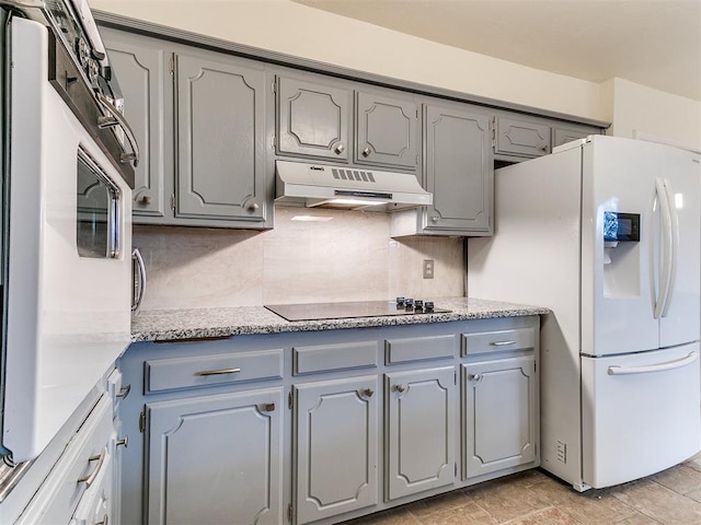 kitchen featuring black electric cooktop, gray cabinets, decorative backsplash, and white fridge with ice dispenser