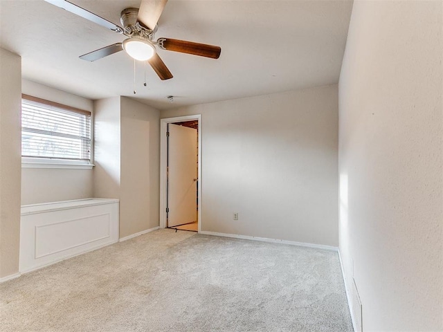 carpeted spare room with ceiling fan