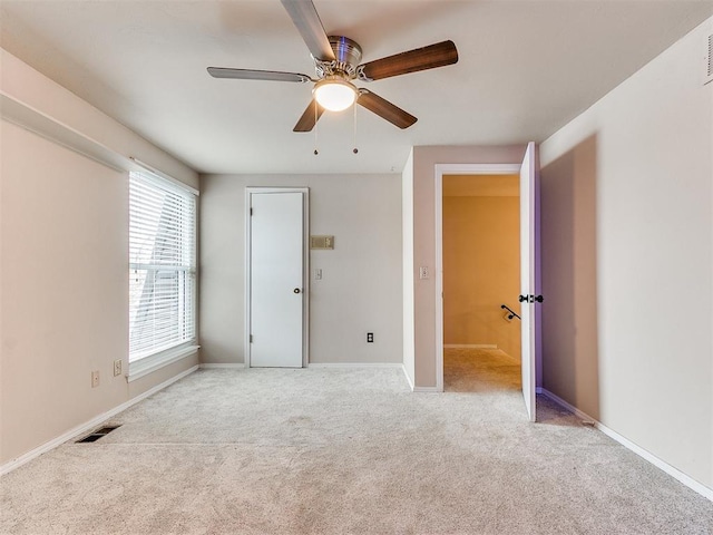 spare room featuring ceiling fan and light colored carpet