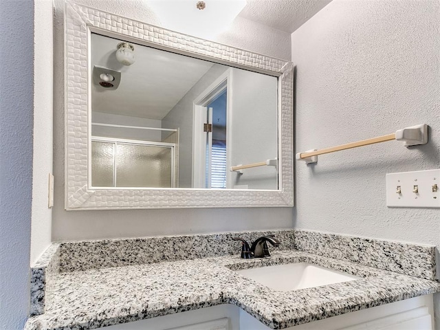 bathroom with vanity and a shower with shower door