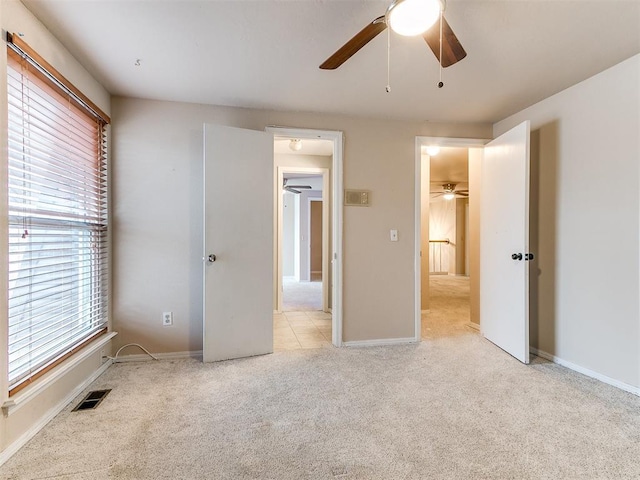 unfurnished bedroom featuring light colored carpet and ceiling fan