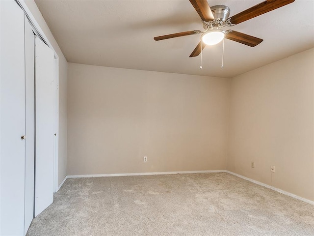 unfurnished bedroom featuring light colored carpet, a closet, and ceiling fan