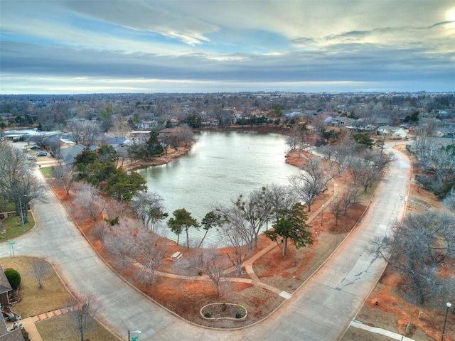 aerial view at dusk featuring a water view