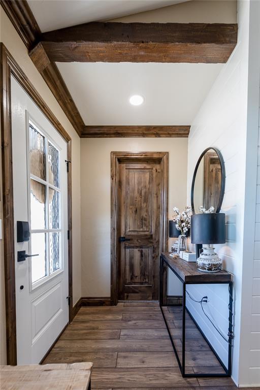 entryway featuring dark wood-type flooring, crown molding, and beamed ceiling