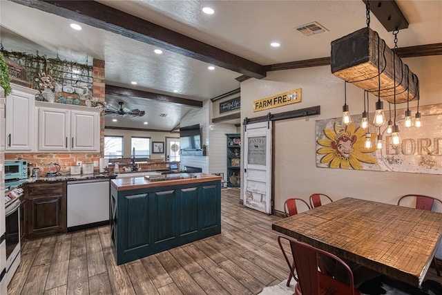 kitchen with a center island, lofted ceiling with beams, dishwasher, a barn door, and white cabinets