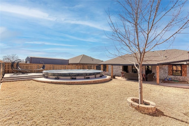 rear view of property featuring an outdoor hangout area, a covered pool, and a patio area