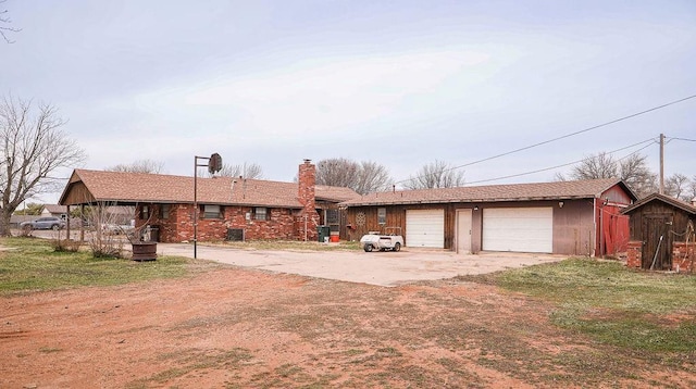 view of front of house featuring driveway, a chimney, and a front yard