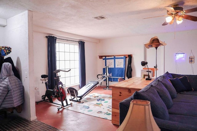 workout room with a textured ceiling, visible vents, and a ceiling fan