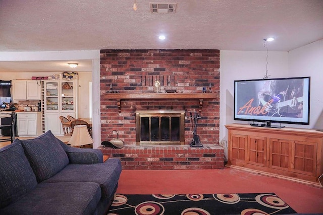 carpeted living area featuring a textured ceiling, a brick fireplace, and visible vents